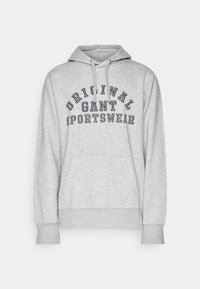Sweat à capuche gris clair avec poche avant et texte noir "ORIGINAL GANT SPORTSWEAR" en arc sur la poitrine.