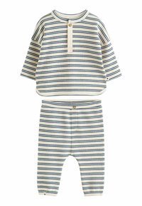 Pruhovaný dvojdielny outfit v krémovej a námorníckej farbe, ktorý obsahuje top s krátkymi rukávmi a detailom gombíka a úzke nohavice s rebrovanou textúrou.