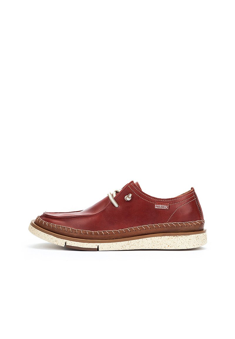 Chaussures en cuir rouge avec une finition lisse, dotées d'un bout rond, d'un laçage et d'une semelle beige mouchetée contrastante. Des coutures mettent en valeur les bords.