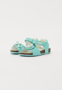 Tyrkis sandaler med sommerfugl detaljer, laget av syntetisk materiale, med justerbare stropper og en kork-strukturert såle.