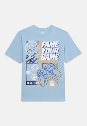 Világoskék póló, amelyen egy focilabda, egy játékkonzol és a következő szöveg látható: "FAME YOUR GAME, READY TO PLAY, LEVEL UP!, FIFA."
