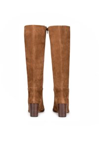 Bottes en suède marron au-dessus du genou avec une fermeture éclair à l'arrière, des talons carrés et une texture lisse. Le talon présente un design en bois légèrement strié.