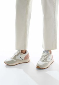 Sneakers con upper in pelle bianca, dettagli in suede grigio e un tallone testurizzato rosa. Completati con una suola in gomma marrone chiaro e lacci.
