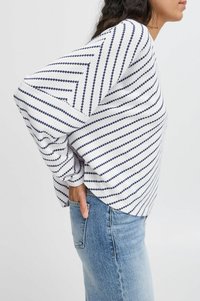 Weißer Pullover mit marineblauen diagonalen Streifen, strukturiertem Strickstoff, lockerer Passform und überschnittenen Schultern, kombiniert mit hellblauer Denim.