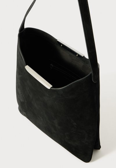 Bolsa de ombro em camurça preta com uma textura lisa, apresentando um detalhe metálico prateado, um topo aberto e um bolso interior com fecho éclair.