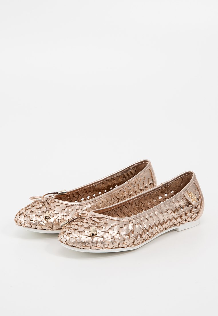 Ballerines en rose doré métallique avec texture tissée, bout arrondi et accent de nœud. Présente des découpes et des semelles plates.