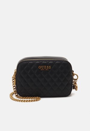 Sac bandoulière en cuir matelassé noir avec bandoulière chaîne dorée et logo ainsi que fermeture éclair GUESS dorés à l'avant.