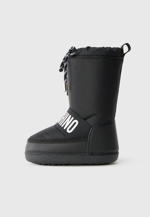 Bottes isolées noires avec finition mate, fermeture à cordon élastique et marquage blanc sur le côté. Semelle texturée pour une meilleure traction.