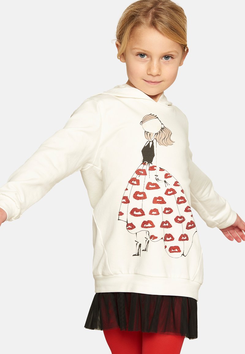 Felpa bianca con un design stampato di una ragazza in un vestito nero con un motivo di labbra rosse, sovrapposto a una gonna di tulle nera.