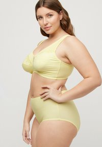 Keltainen rintaliivisetti ja korkeavyötäröiset alushousut, joissa on ribbikuviointi, kukkakirjailu ja aaltoileva reuna.