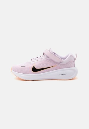 Chaussure de course Nike rose clair avec logo noir, semelle blanche épaisse étiquetée ComfiRide, et une bride Velcro sur les lacets sur fond blanc.