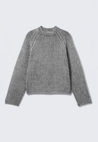 Pull en maille côtelée à manches longues, avec des rayures verticales noires et blanches et un col haut côtelé, posé à plat sur un fond clair.