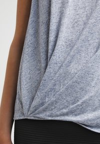 Šedý, melírovaný, krátký rukáv top s volně splývavým designem a detailem uzlu na boku. Vyrobeno z měkké tkaniny. Vodorovný černý pruh níže.