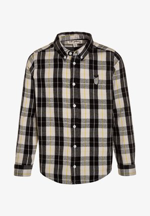 Chemise à carreaux noirs, gris et jaunes en flanelle ; présente un col boutonné, des manches longues et une broderie de hibou.