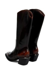Botas altas de cuero marrón con un acabado suave, punta cuadrada y tacón grueso negro acentuado con herrajes de plata. Detalle de cremallera en el lateral.