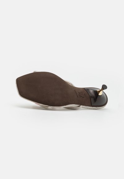 Semelle de chaussure marron avec une finition lisse et texturée, bordée d'une garniture décorative à perles. Présente un talon élégant et un design minimaliste.