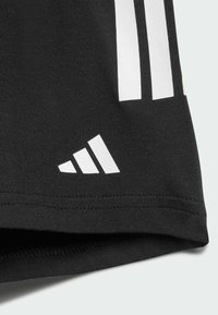 Black athletic shorts made of cotton blend material featuring three white vertical stripes and a white Adidas logo near the hem.