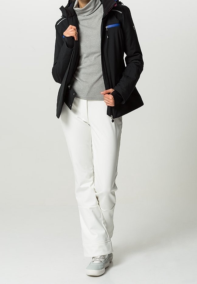 Svart softshell-jacka med huva, grå polo-krage, och vita byxor, med dragkedjefickor och en avslappnad passform. Skorna är ljusgrå.