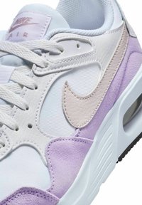 Sneaker bianco e lavanda con dettagli in pelle texturizzata e camoscio, dotato di una tomaia in mesh, lacci e un'unità Air visibile nella suola.