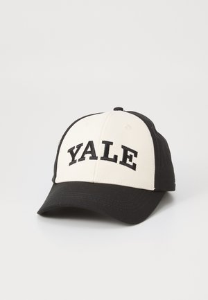 Gorra de béisbol negra y crema con "YALE" en letras negras y en negrita en la parte frontal. Material de algodón con una corona estructurada y un visera curva.