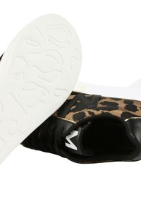 Un paio di sneaker leopardate marroni e nere con suole bianche testurizzate e lacci neri, con una scarpa che mostra il motivo della suola.