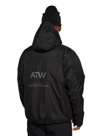 Mann trägt schwarze Kapuzenjacke mit grauem Schriftzug "ATW" und "Off Duty Gear Halo" auf dem Rücken, kombiniert mit schwarzer Mütze und Hose, von hinten gezeigt.