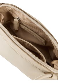 Beige bőrtáska belső részén cipzáras zseb és béléses rekeszek találhatóak. Simaság jellemzi, és az oldalán egy márkás címke van belevarrva.