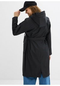 Impermeabile nero con cappuccio, cintura in vita regolabile e tasche laterali. Presenta un retro ventilato per la traspirabilità e una vestibilità comoda.