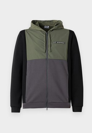 Dlhý zips so spojmi farieb zelená, šedá a čierna. Obsahuje odnímateľnú kapucňu, elastické manžety a akcent s logom na hrudi.