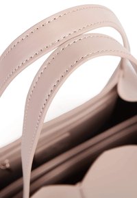 Ustrukturyzowana różowa skórzana torebka z dwoma szerokimi paskami, z starannym przeszyciem. Wnętrze prezentuje gładkie wykończenie i zaokrąglony kształt.