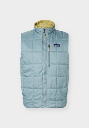 Hele sinine tikitud varrukateta vest beeži voodriga, ees tõmblukk, tõmblukuga rinnatasku ja Patagonia logo rinnal.