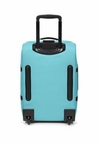 Ein türkisfarbener Rollkoffer mit hartem schwarzem Boden, Doppelrollen und ausziehbarem Griff. Verfügt über verstärkte Ecken und seitliche Griffe.