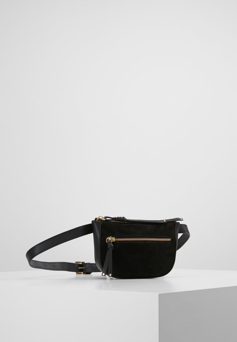 Musta nahka- ja mokkanahkainen vyölaukku, jossa pyöreä muoto, kullanvärinen vetoketju ja säädettävä hihna. Siinä on yksi etutasku vetoketjulla ja hapsukoriste.
