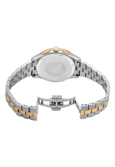 Stříbrné a zlaté nerezové hodinky se dvoutónovým náramkem, vybavené skládací sponou a kulatým pouzdrem. Na zadní straně je vytištěno logo a text.