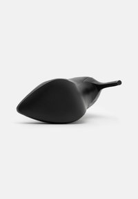 Zapato de tacón alto negro con punta afilada, parte superior de cuero suave y suela de goma texturizada con estrías para mayor agarre.