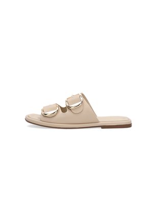 Beige flad sandal med to brede remme og store guldfarvede spænder på en brun sål, vist i sideprofil.