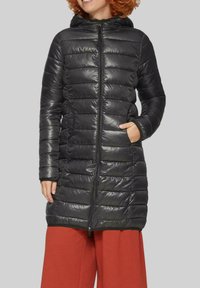 Schwarze Steppjacke mit glänzender, gesteppter Textur, durchgehendem Reißverschluss, Kapuze und seitlichen Taschen; knielanges Design, geeignet für kaltes Wetter.