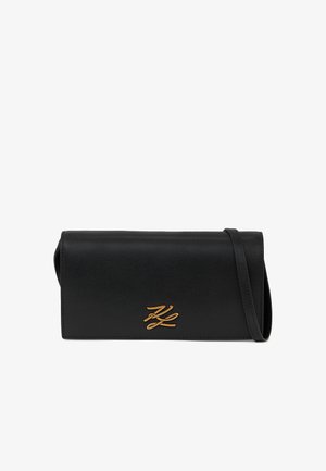 Schwarze Leder-Clutch mit einem schmalen Riemen und goldenen dekorativen Initialen in der Mitte vorne.