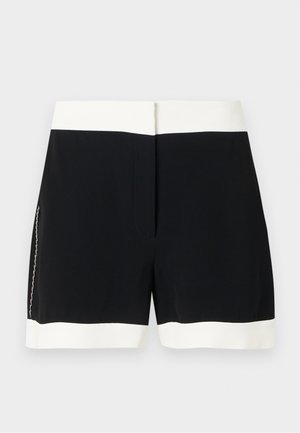 Shorts noirs avec une taille et un ourlet blancs, dotés d'une fermeture éclair latérale discrète, présentés sur un fond uni.
