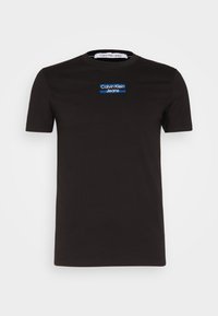 Black cotton T-shirt with short sleeves, featuring a blue and white "Calvin Klein Jeans" logo on the chest. Crew neck design.