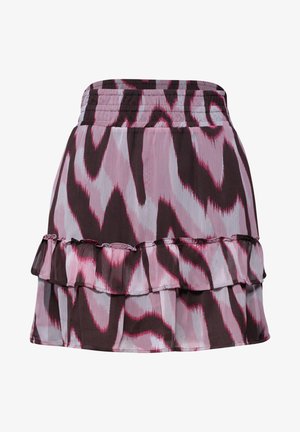 Talje til midt lår på en person iført en hvid skjorte og et abstrakt mønstret nederdel i pink, sort og hvid med elastik i taljen og sidelomme.