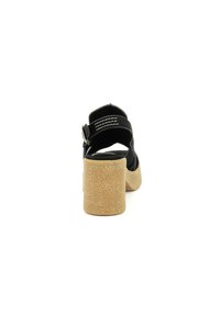 Sandalo in suede nero con tacco spesso beige testurizzato, cinturino alla caviglia regolabile e design aperto sul retro. Accenti di cucitura sul cinturino.