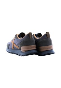 Sportske cipele sa tamno sivim i smeškim dizajnom koje kombinuju glatke i nubuk teksture. Gumenim đonovima i uočljivim brendiranim logotipom na peti.