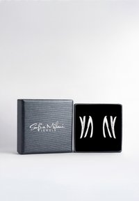 Silverörhängen med en böjd design, prydda med strukturerade detaljer, visade i en svart sammetspänt, silvertexturerad box.