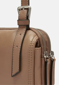 Borsa in pelle marrone con finitura testurizzata, dotata di una cerniera argentata, accenti a contrasto e una tracolla regolabile.