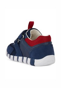 Sneaker blu navy con un mix di mesh e suede, accenti in tessuto rosso, chiusura in velcro e suola in gomma bianca con grip testurizzato.