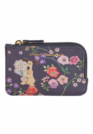 Piccolo portafoglio blu navy con motivo floreale, un cane che tiene fiori bianchi e testo dorato con la scritta Cath Kidston x Wallace & Gromit.