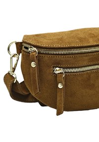 Sac en cuir suédé marron à bandoulière, avec deux compartiments zippés, quincaillerie argentée et bandoulière ajustable. Texture douce et forme arrondie.