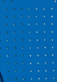 Sininen kangas, jossa on sileä pinta, jossa on tasaisesti sijoitettuja vihreitä ja kirkas koristeellisia swarovski-kristalleja ruudukkomuodostelmassa.