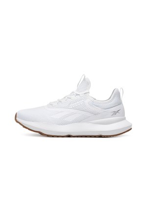 Baltās sporta kurpes ar elpojošu sietu augšdaļu, noapaļotu purngalu, mīkstinātu zoli un teksturētu gumijas ārējo zoli. Ar Reebok zīmolu.